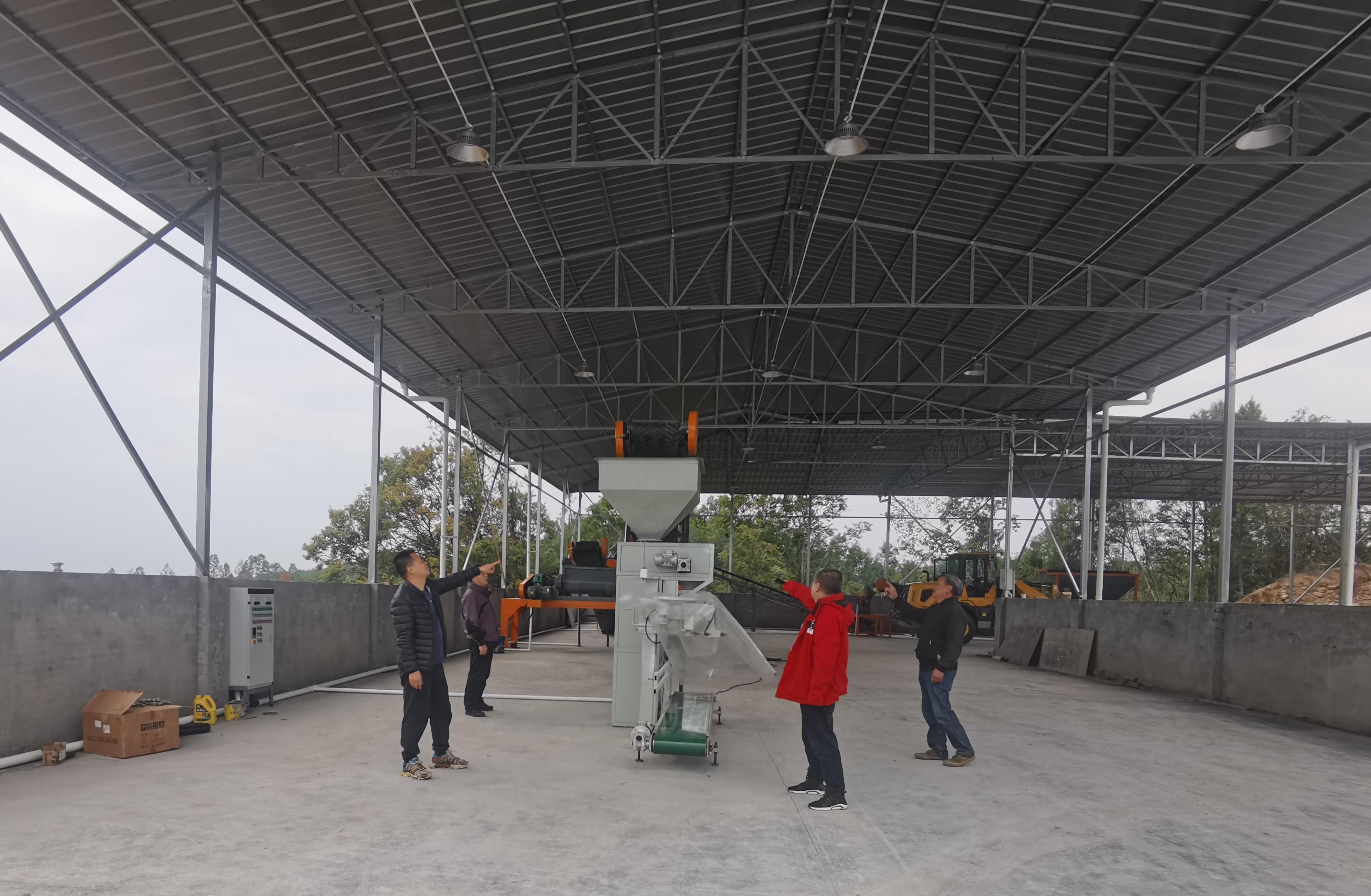 李杰超（左一）與村社干部、駐村隊員查看有機肥廠設(shè)備采購情況